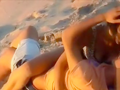 Attractive doll enjoys a man's cock in the sand