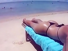 Desirable dish lets her man put sunscreen on her slim body