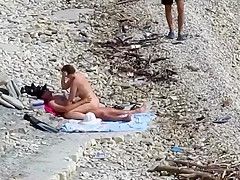 Sensual girl jumps on her boyfriend's fat dick at the nude beach
