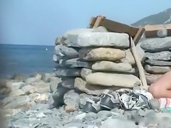 Naked Crimean chick reads magazine at the beach