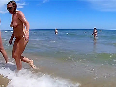 Older people walk around the beach completely naked