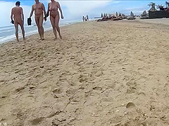 Older people walk around the beach completely naked
