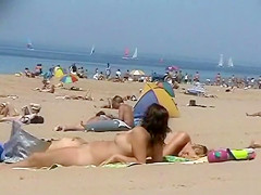 Sunny day at the public beach with two nudist girls