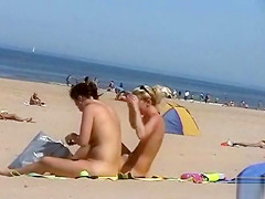 Sunny day at the public beach with two nudist girls