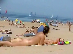 Sunny day at the public beach with two nudist girls