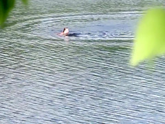 Nudist couple has fun in the middle of a beautiful lake