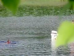 Nudist couple has fun in the middle of a beautiful lake