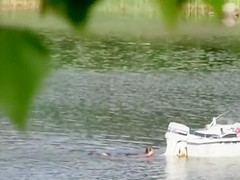 Nudist couple has fun in the middle of a beautiful lake