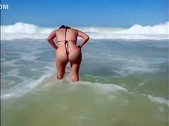 Large-assed harlot wears a flimsy bikini to the beach
