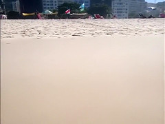 Large-assed harlot wears a flimsy bikini to the beach