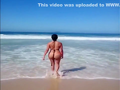 Large-assed harlot wears a flimsy bikini to the beach