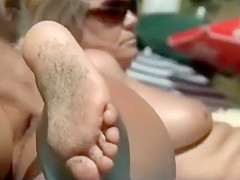 Tanned ass at the beach gets oil rub