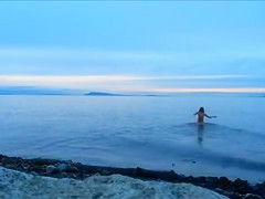 Naked woman greets the beauty of the sea