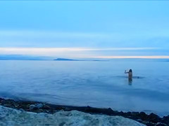 Naked woman greets the beauty of the sea