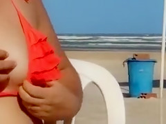 Chubby woman sets up her red bikini at the beach