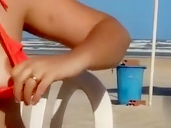 Chubby woman sets up her red bikini at the beach