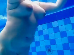 Curvy naked body floats in the pool
