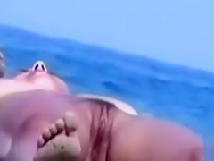 Curvy girl sunbathes her perfect body by the sea