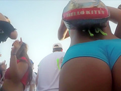 Foxy coquette walks in the crowd in a flimsy bikini