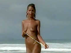 Deeply tanned teen poses for pictures on the nudist beach
