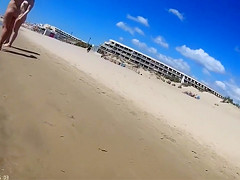 Group of mature nudists walks around the beach naked