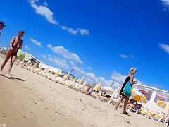Group of mature nudists walks around the beach naked