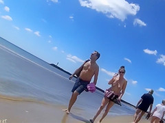 Group of mature nudists walks around the beach naked