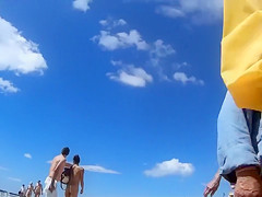 Group of mature nudists walks around the beach naked