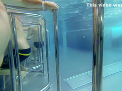 Nudist woman enjoys bating under the water