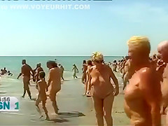 Mature Spanish nudists walk around the beach completely naked