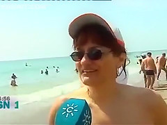 Mature Spanish nudists walk around the beach completely naked