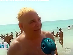 Mature Spanish nudists walk around the beach completely naked