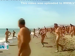 Mature Spanish nudists walk around the beach completely naked