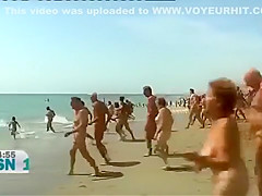 Mature Spanish nudists walk around the beach completely naked