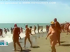 Mature Spanish nudists walk around the beach completely naked