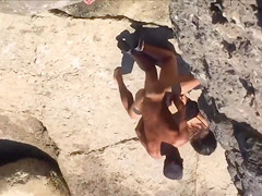 Filly's pussy gets penetrated on the rocky beach