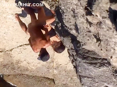 Filly's pussy gets penetrated on the rocky beach