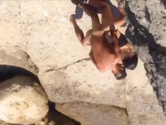 Filly's pussy gets penetrated on the rocky beach
