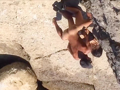 Filly's pussy gets penetrated on the rocky beach