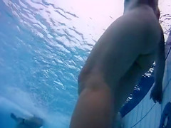Naked men and women in the pool filmed underwater