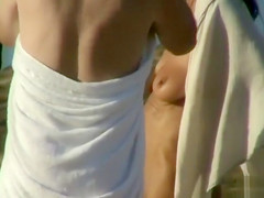 Naked ladies at the beach dry off after a swim