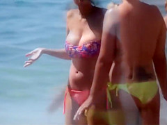 Pretty girls with big boobs tanning in the sand