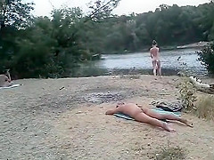 Slender nudist goes for a swim in the lake