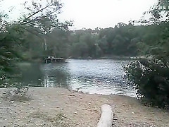 Slender nudist goes for a swim in the lake