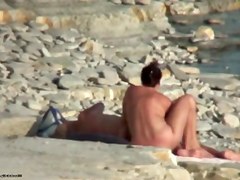 Hot cougar is lying on sand in naked beach video