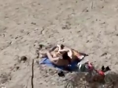 A Voyeur films a pair on beach