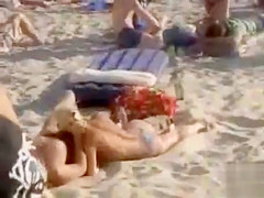 Doing the fellatio on a crowded beach