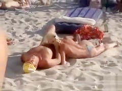 Doing the fellatio on a crowded beach