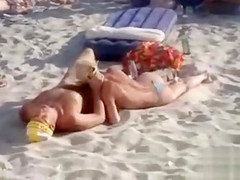Doing the fellatio on a crowded beach