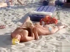 Doing the fellatio on a crowded beach